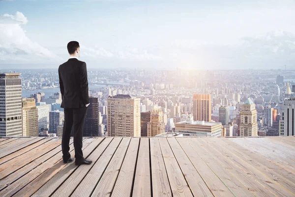 Young businessman on pier looking at city with sunlight and copy space. Research concept — Stock Photo, Image