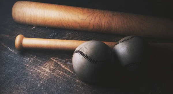 Две бейсбольные мячи и летучие мыши на деревянном столе — стоковое фото