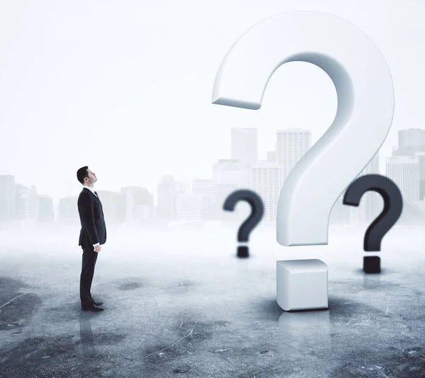 Side view of young adult businessman looking at question marks on abstract foggy gray background. Questionnaire concept. 3D Rendering — Stock Photo, Image