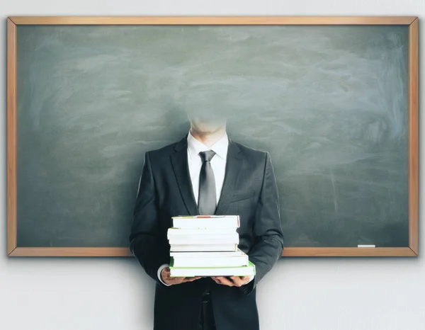 Pengusaha tanpa kepala dengan buku di latar belakang papan tulis. Konsep pengetahuan — Stok Foto