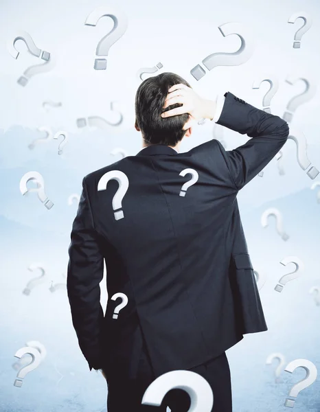 Thoughtful businessman with questions — Stock Photo, Image