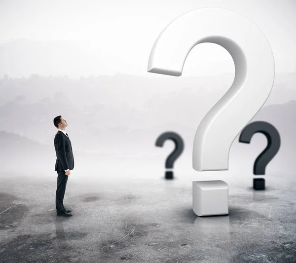 Side view of young adult businessman looking at question marks on abstract foggy gray background. Doubt concept. 3D Rendering — Stock Photo, Image