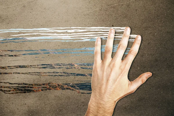 Male hand wiping concrete background and revealing mountain view. Abstract concept