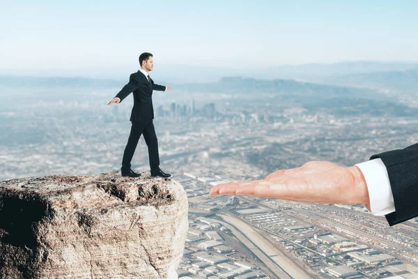 Zijaanzicht van balancing zakenman intensivering op enorme palm op de achtergrond van de stad. Steun concept — Stockfoto
