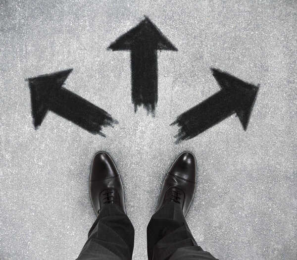 Top view of businessman feet on concrete floor with drawn arrows. Opportunity concept 