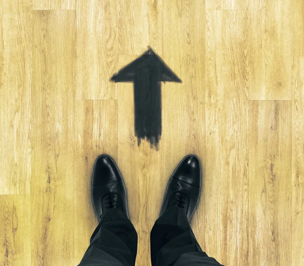 Vista superior de los pies de los hombres de negocios en el suelo de madera con flecha dibujada. Concepto de inicio — Foto de Stock