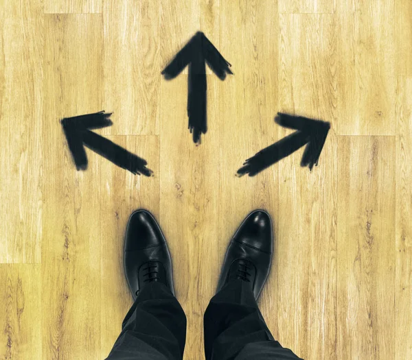 Bovenaanzicht van zakenman voeten op houten vloer met getrokken pijlen. Pad concept — Stockfoto