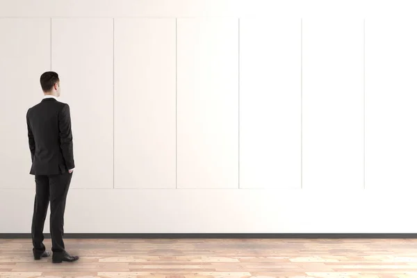 Businessman looking at blank wall — Stock Photo, Image