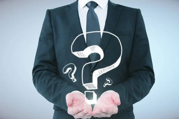 Businessman holding question marks — Stock Photo, Image