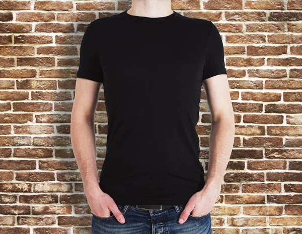 Man wearing black shirt on brick background — Stock Photo, Image