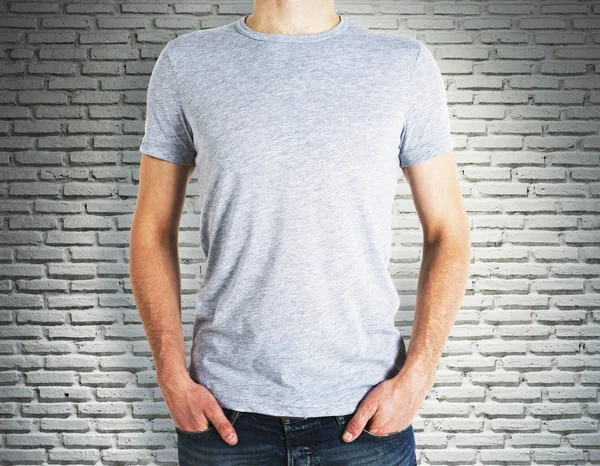 Homem vestindo camisa em branco no fundo de tijolo — Fotografia de Stock