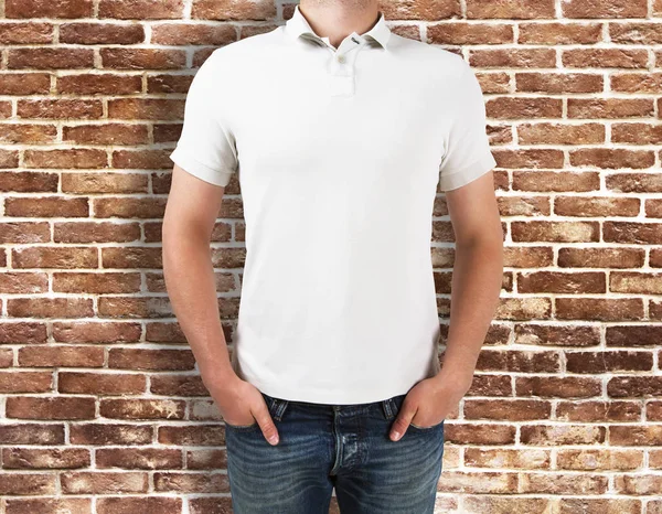 Homem vestindo camisa branca no fundo de tijolo — Fotografia de Stock