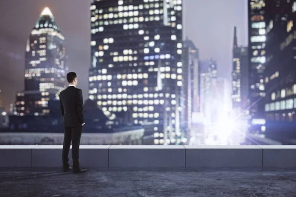 Uomo d'affari guardando la città di notte — Foto Stock