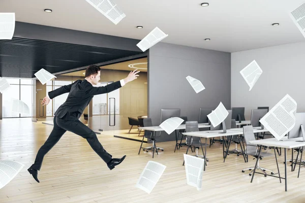 Businessman jumping in concrete office