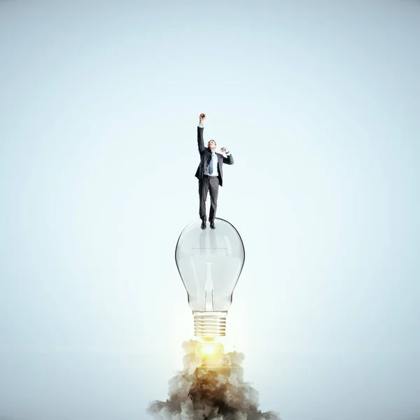 Businessman flying with launching lamp — Stock Photo, Image