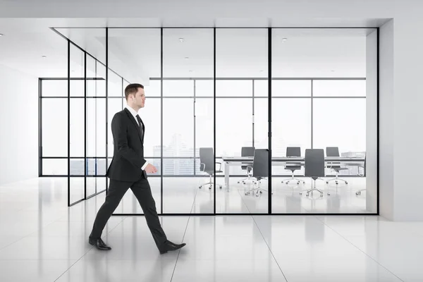 Empresário andando na sala de reuniões brilhante — Fotografia de Stock