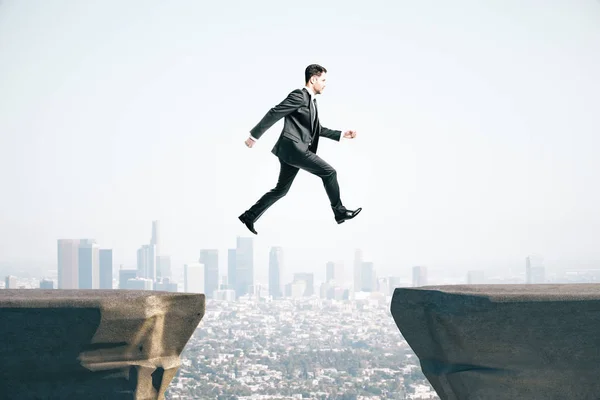 Businessman in suit jumping on mountain — 스톡 사진