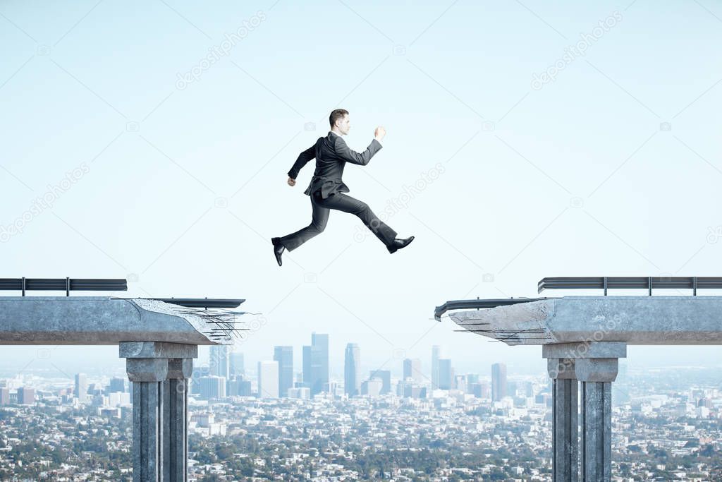 Businessman jumping over gap in bridge