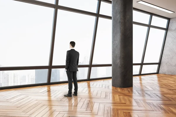 Businessman standing in minimalistic gallery interior — 스톡 사진