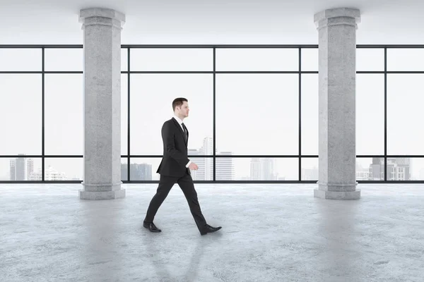 Businessman walking in modern gallery interior — 스톡 사진