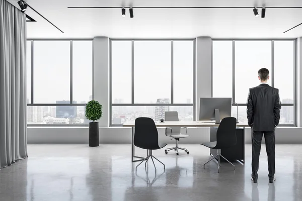 Businessman standing in bright contemporary office — Stock Photo, Image