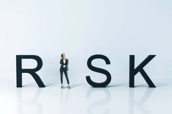 Thinking businesswoman standing near risk text. — Stock Photo, Image