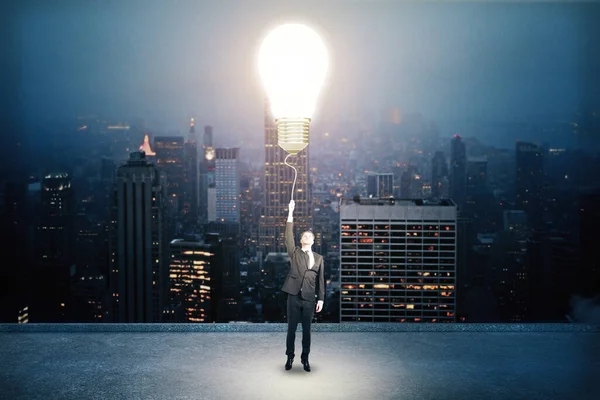 Affärsman som håller glödlampa — Stockfoto