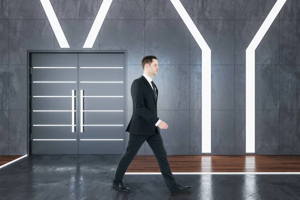 Podnikatel kráčí v futuristickém sále interiéru — Stock fotografie