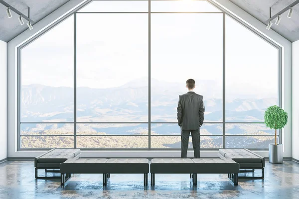 Zakenman standinf in minimalistische zolderkamer — Stockfoto