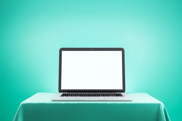 Modern designer desktop with empty white laptop screen on green wall background. Mock up. 3D Rendering