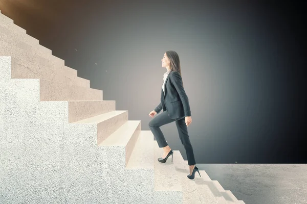 Side view of businesswoman climbing on stairs. Career development and job concept