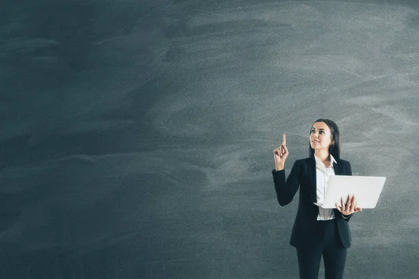 Businesswoman with document in hand and blank blackboard. Business and success concept.