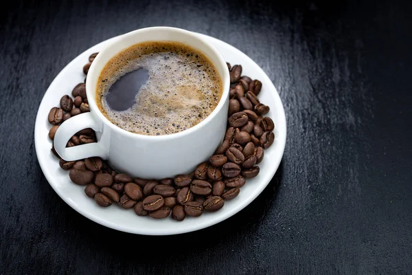 Tasse à café et soucoupe sur une table en bois. Fond sombre. — Photo