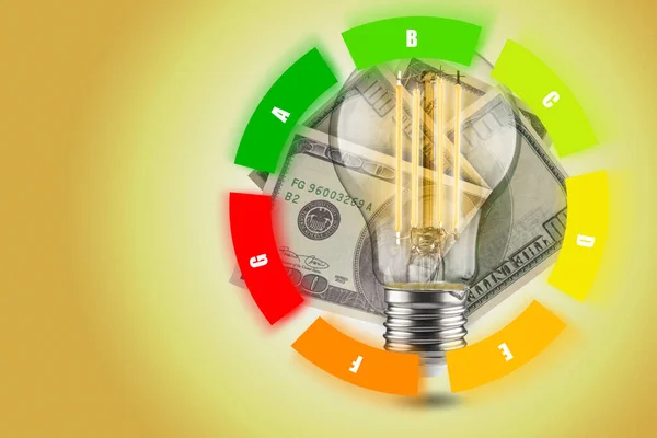 Energy efficiency concept of LED lamps. Decrease in electricity consumption. LED light bulb with dollars on a yellow background. Circular table.