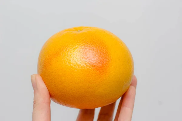 Orange Grapefrukt Med Röd Sida Handen Vit Bakgrund — Stockfoto