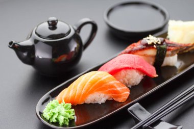 Ton balığı, somon ve yılan balığı suşi nigiri siyah masada
