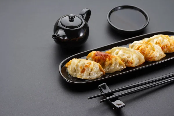 A plate of Japanese gyoza over black background — Stock Photo, Image