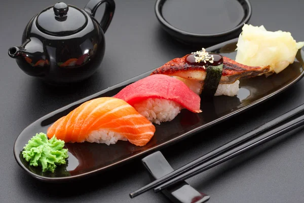 Tonfisk, lax och ål nigiri sushi på tabellen svart — Stockfoto