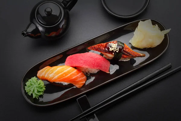 金枪鱼、 三文鱼和鳗鱼寿司饭上黑色的桌子 — 图库照片
