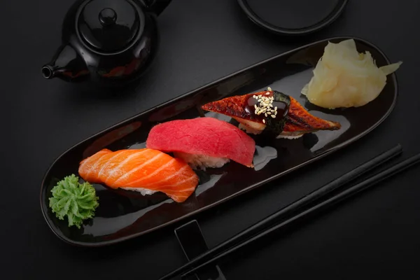 Tuna, salmon and eel sushi nigiri on the black table — Stock Photo, Image