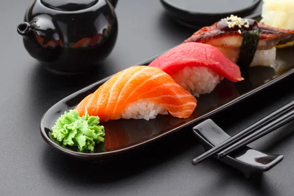 Tonfisk, lax och ål nigiri sushi på tabellen svart — Stockfoto