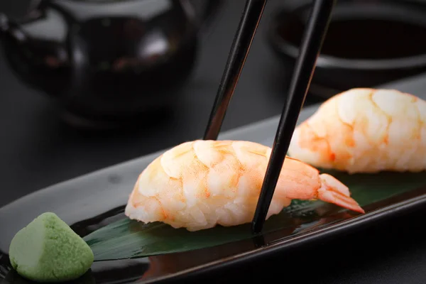 Sushi nigiri di gamberetti su un piatto nero su sfondo scuro — Foto Stock