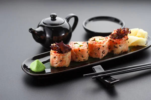 Sushi dengan udang dan tobiko merah di mamenori pada piring hitam — Stok Foto