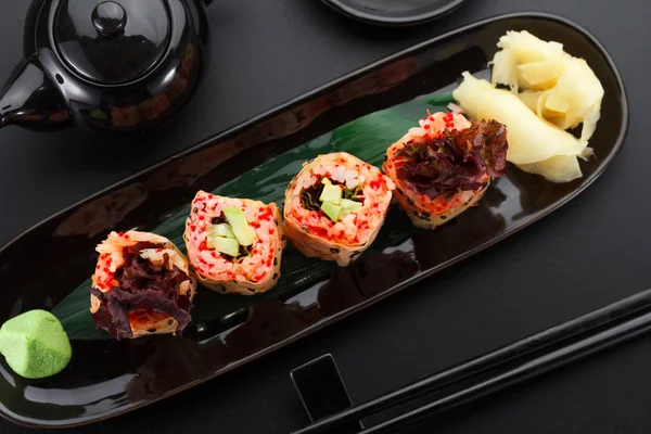 Sushi with shrimp and red tobiko in mamenori on a black plate — Stock Photo, Image