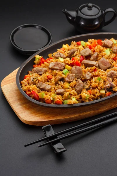 Cozinha japonesa. Arroz com carne de porco sobre fundo preto . — Fotografia de Stock