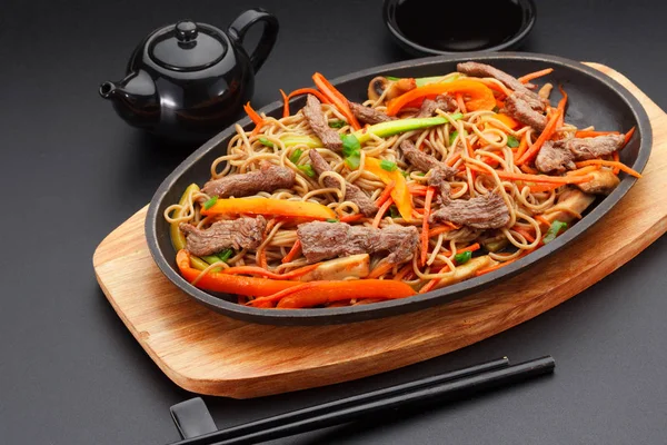 Soba noodles with veal over black background — Stock Photo, Image