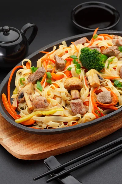 Asia food. Udon noodles with pork on a black table. — Stock Photo, Image