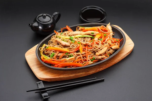Soba noodles with pork on a black table — Stock Photo, Image