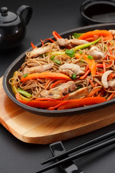 Soba noodles with chicken on a black table. — Stock Photo, Image