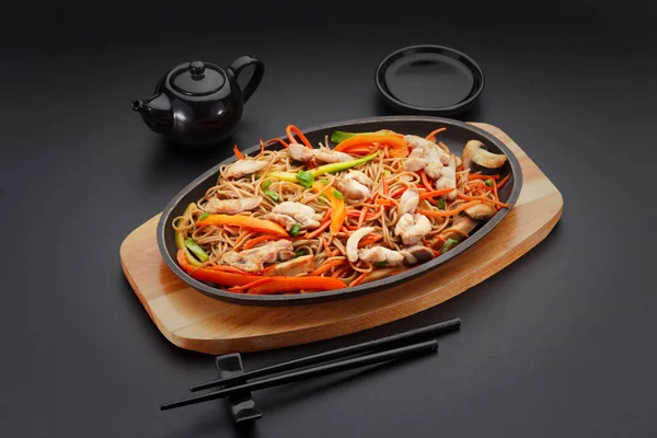 Soba noodles with chicken on a black table. — Stock Photo, Image